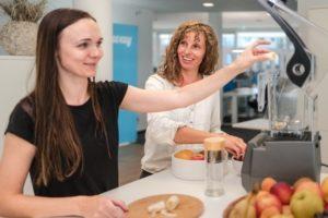 Zwei Frauen im Büro bei der Zubereitung von Smoothies